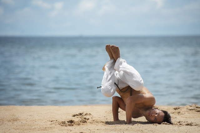 shirtless man practicing capoeira by himself beach1